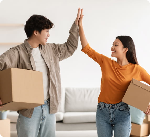 young-couple-with-cardboard-boxes-high-fivin